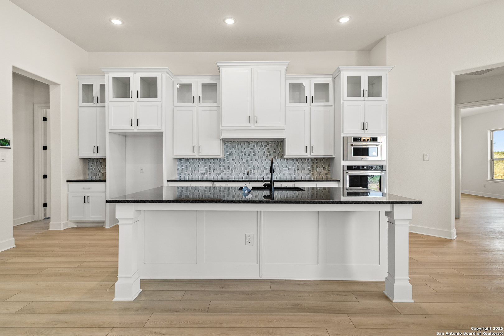 241 Stone Loop Castroville, TX 78009 - Photo 9 of 23 a large kitchen with stainless steel appliances granite countertop a stove a sink and white cabinets