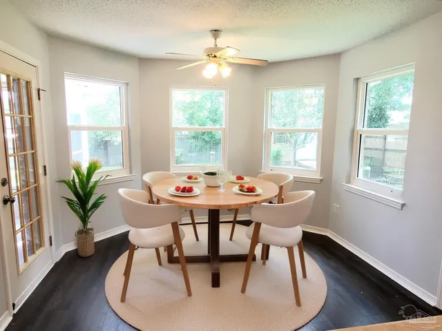 a dining room with furniture potted plants and wooden floor