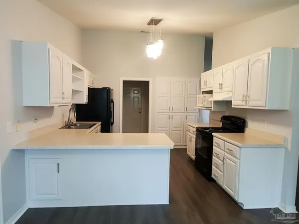 a kitchen with stainless steel appliances a refrigerator stove top oven and sink