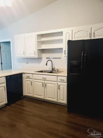 a kitchen with a sink a refrigerator and cabinets