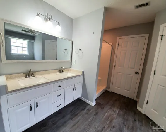 a spacious bathroom with a double vanity sink and mirror