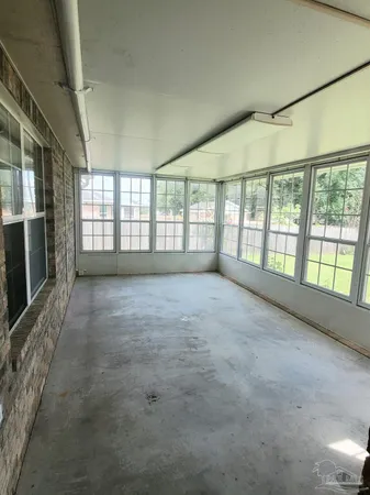 a view of an empty room with a fireplace and a window