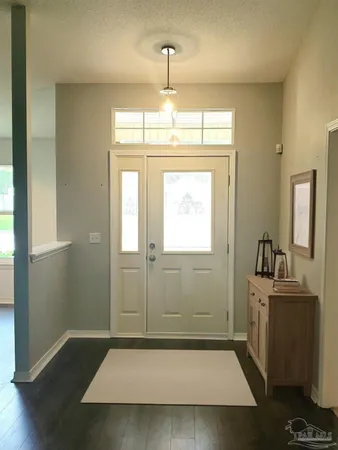 a view of a hallway with entryway wooden floor and windows