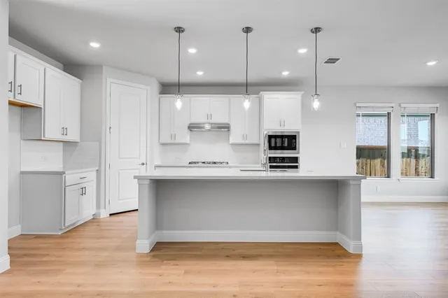 a open kitchen with kitchen island a sink stainless steel appliances and cabinets