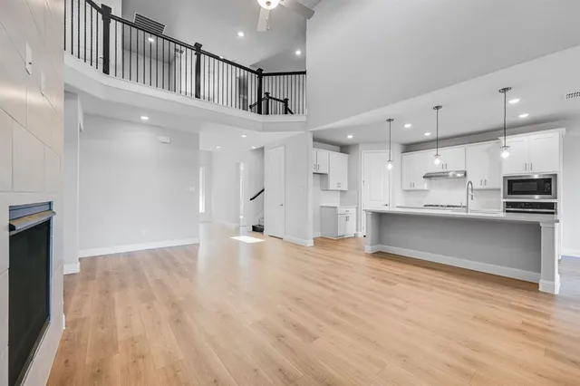 a view of kitchen with kitchen island wooden floor center island and stainless steel appliances