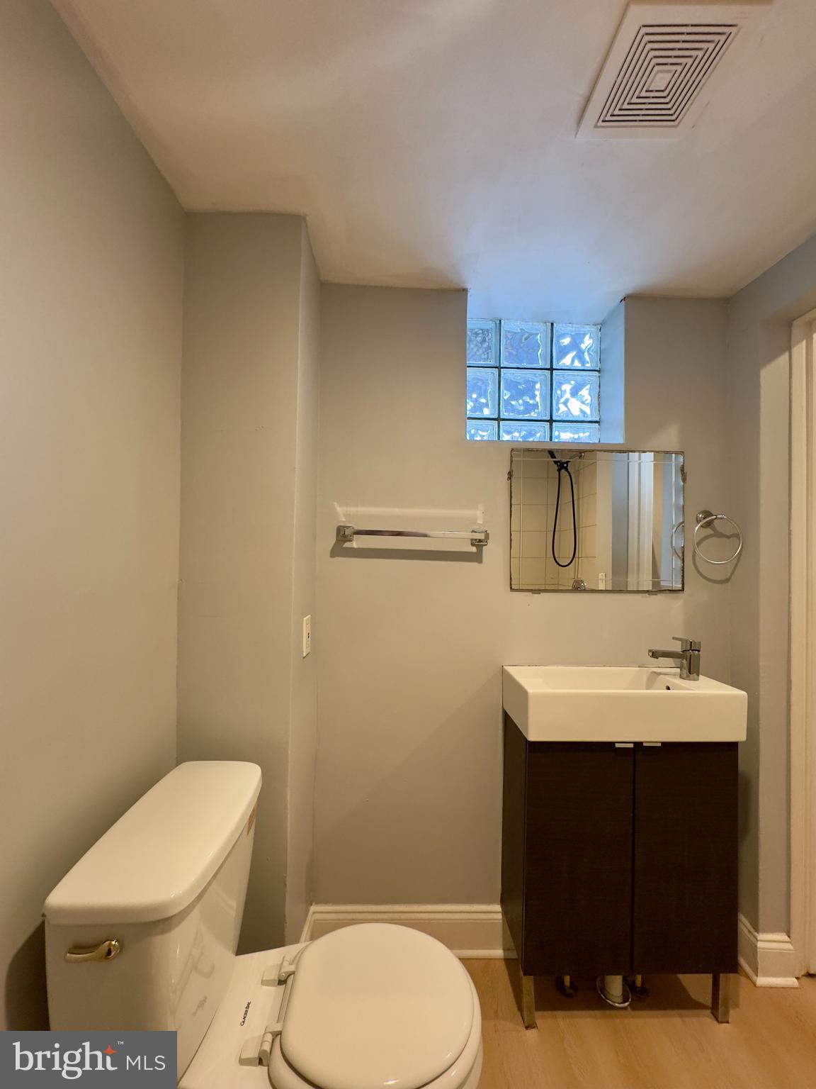 408 South Conkling Street, Unit 1 Baltimore, MD 21224 - Photo 12 of 14 a bathroom with a toilet a sink and mirror