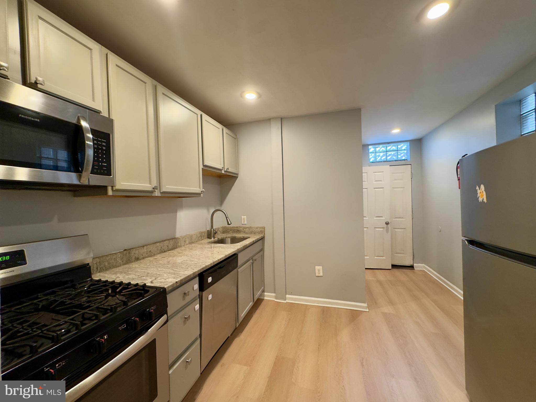 408 South Conkling Street, Unit 1 Baltimore, MD 21224 - Photo 8 of 14 a kitchen with stainless steel appliances granite countertop a stove a sink and a microwave
