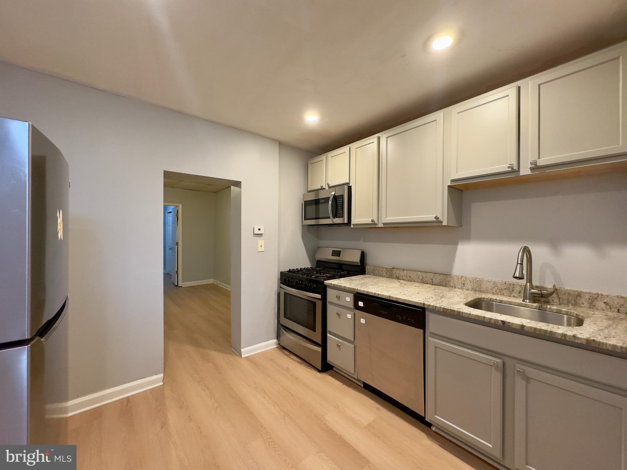 408 South Conkling Street, Unit 1 Baltimore, MD 21224 - Photo 9 of 14 a kitchen with stainless steel appliances granite countertop a stove a sink and a refrigerator