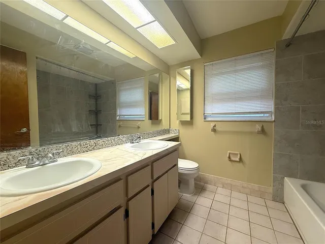 a bathroom with a granite countertop sink a mirror and a toilet