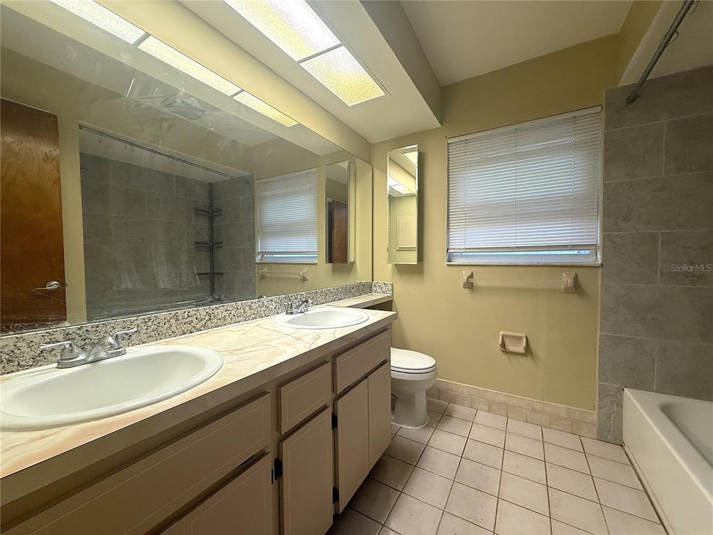 8840 Martinique Lane Port Richey, FL 34668 - Photo 14 of 31 a bathroom with a granite countertop sink a mirror and a toilet