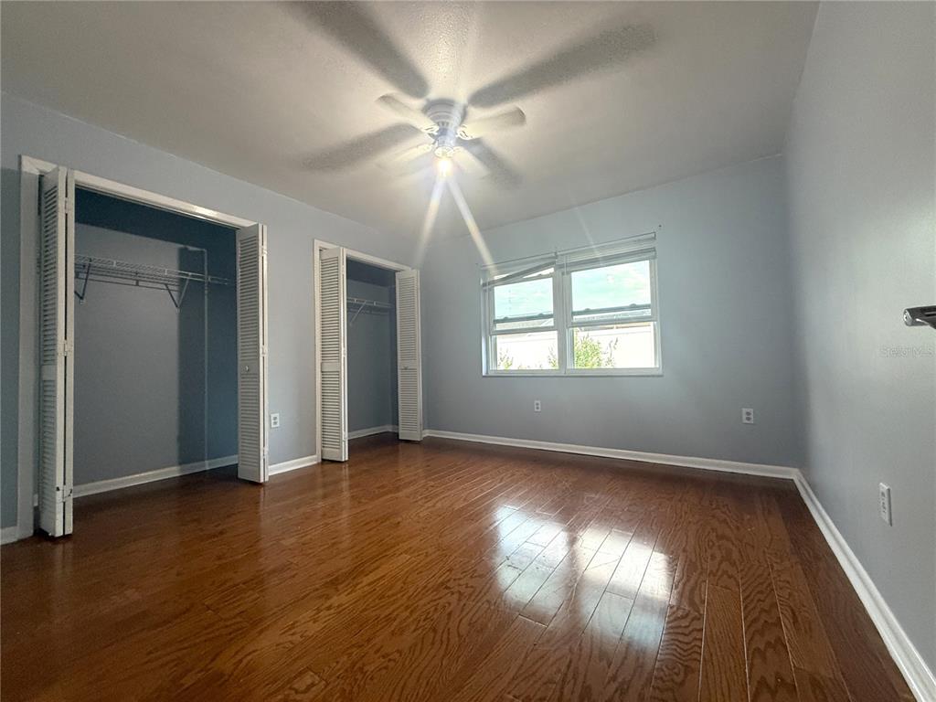 8840 Martinique Lane Port Richey, FL 34668 - Photo 22 of 31 a view of an empty room with wooden floor and a window