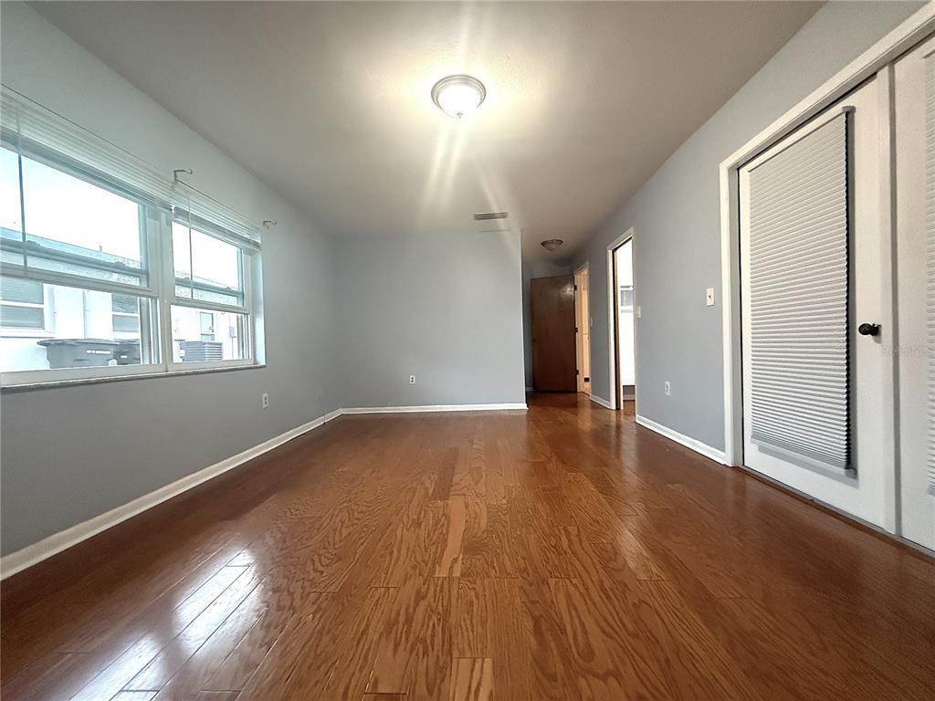 8840 Martinique Lane Port Richey, FL 34668 - Photo 24 of 31 a view of an empty room with wooden floor and a window