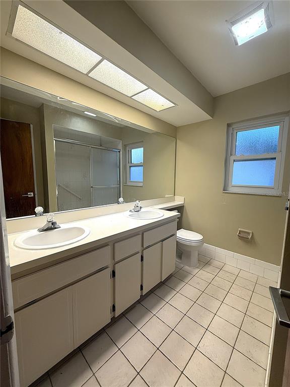 8840 Martinique Lane Port Richey, FL 34668 - Photo 25 of 31 a bathroom with a double vanity sink mirror and toilet
