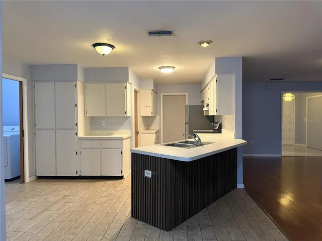 a kitchen with a sink cabinets and wooden floor
