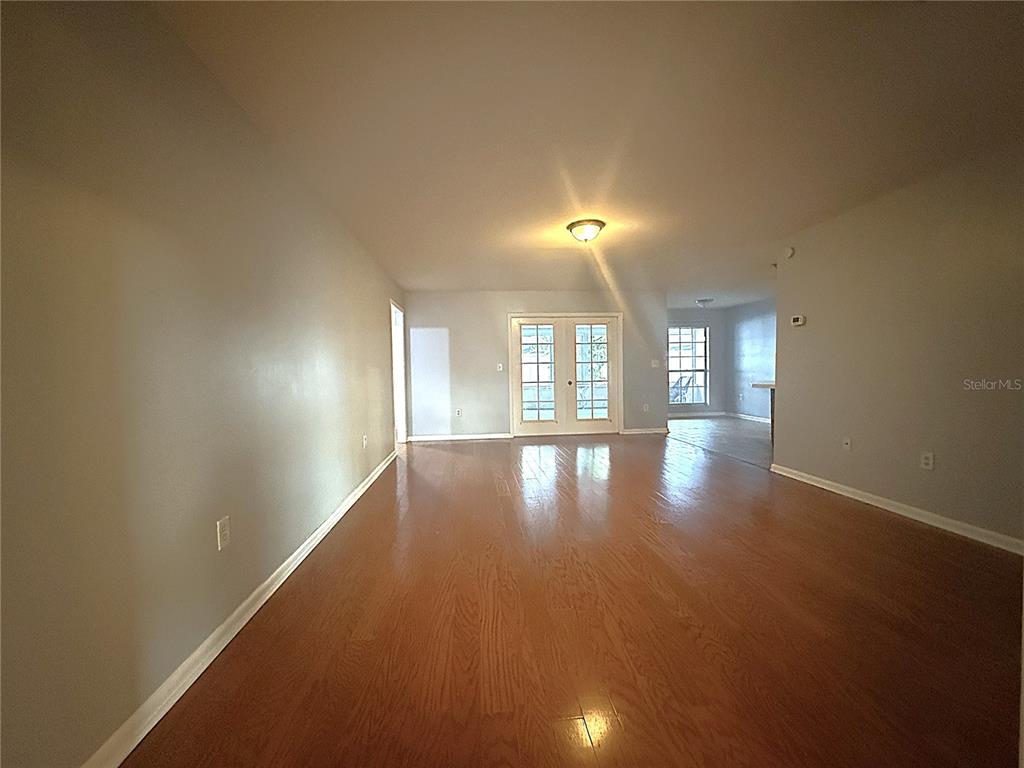 8840 Martinique Lane Port Richey, FL 34668 - Photo 8 of 31 an empty room with wooden floor and windows