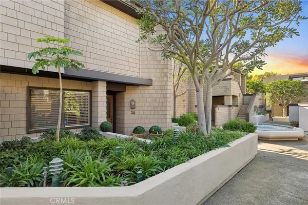a front view of a house with a yard and potted plants