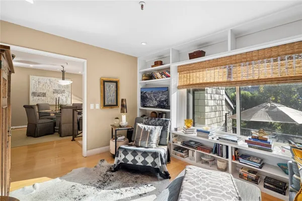 a living room with furniture large window and wooden floor