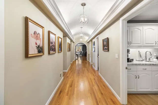 a view of a hallway with wooden floor and staircase