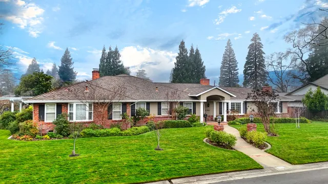 a front view of a residential houses with yard and green space