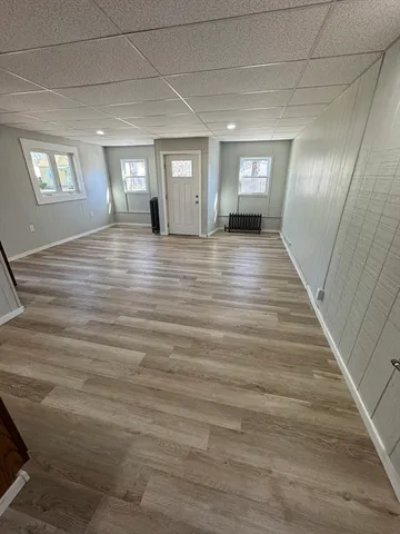 a view of empty room with window and wooden floor