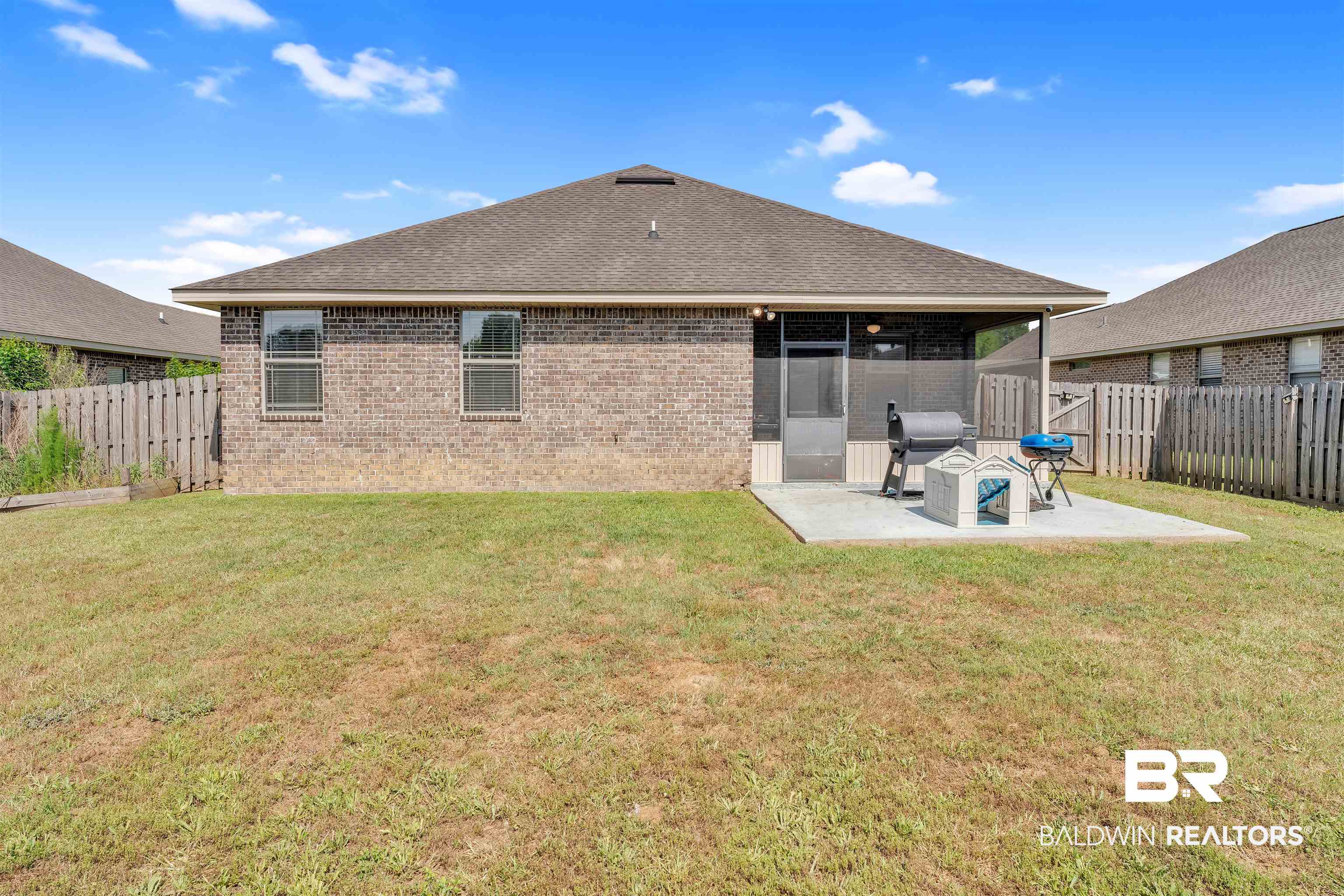 22565 Nana Loop East Silverhill, AL 36576 - Photo 24 of 26 Back of property with a yard, a patio area, brick siding, and a fenced backyard