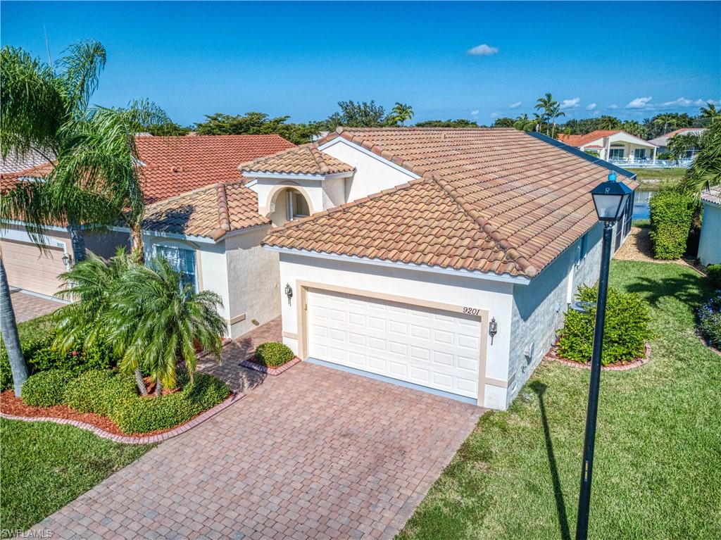 a view of a house with a yard and potted plants