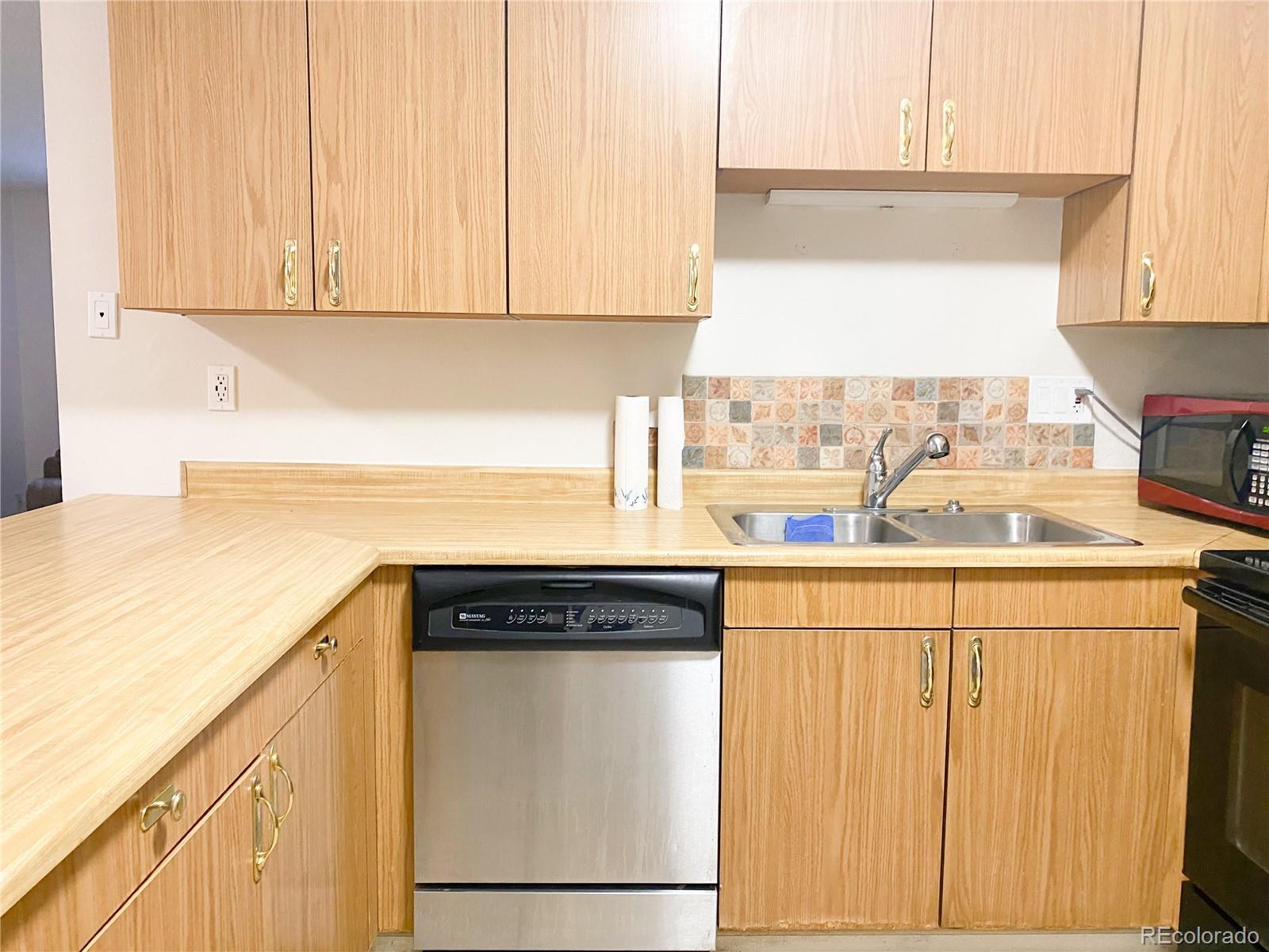8423 Everett Way, Unit B Arvada, CO 80005 - Photo 12 of 27 a kitchen with granite countertop white cabinets and a sink