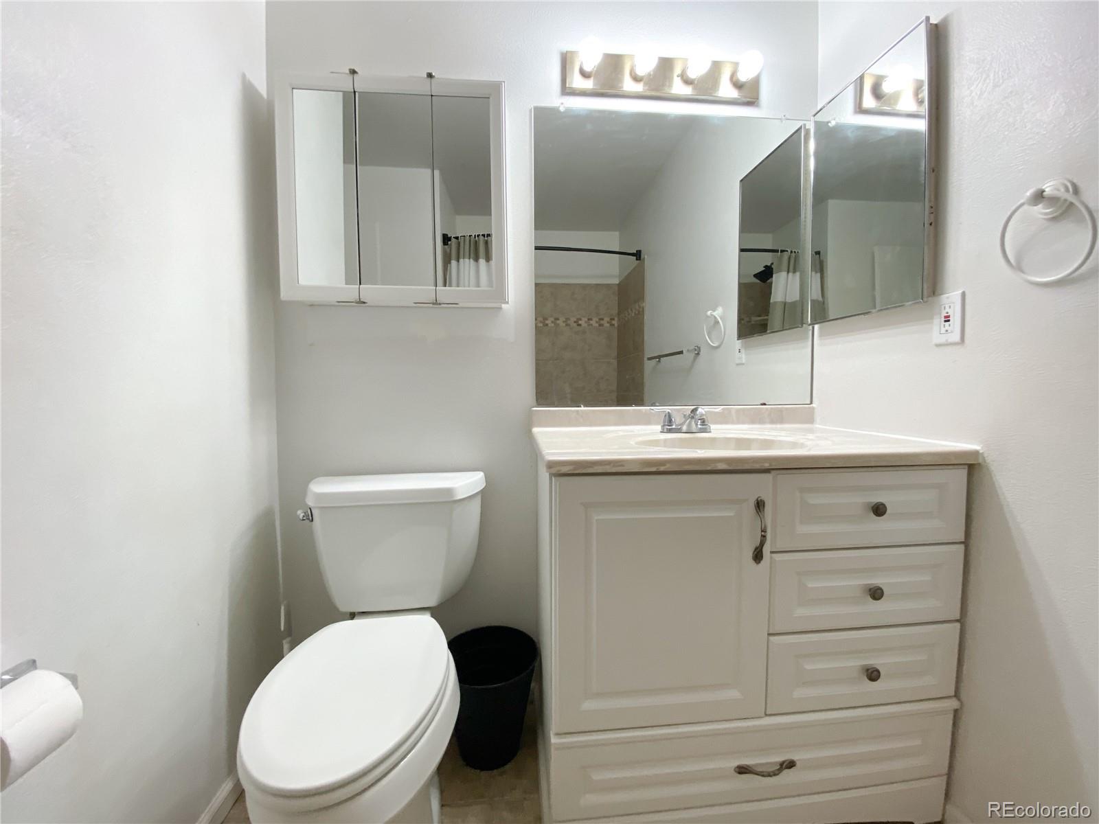 8423 Everett Way, Unit B Arvada, CO 80005 - Photo 19 of 27 a bathroom with a toilet sink and mirror