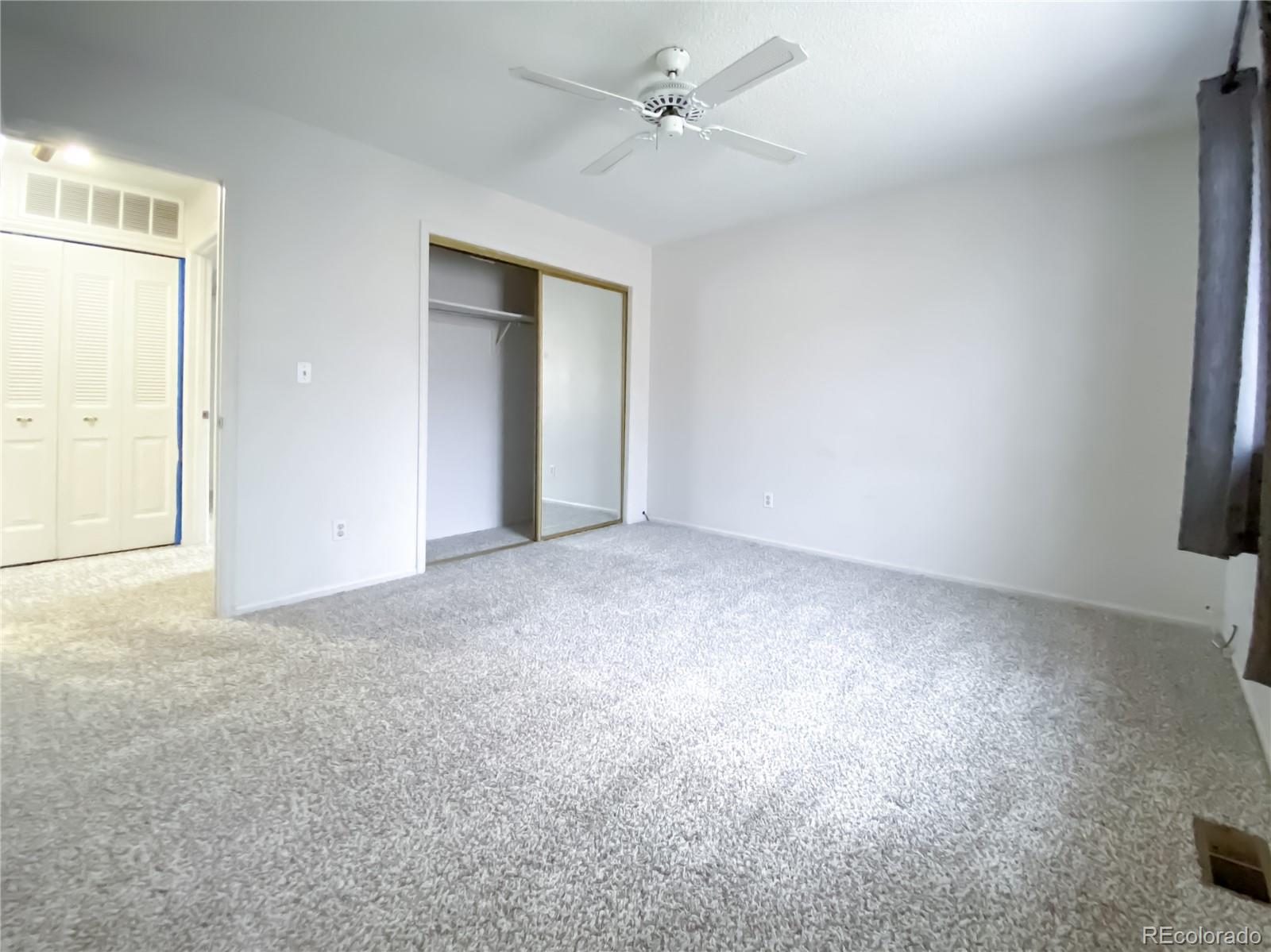 8423 Everett Way, Unit B Arvada, CO 80005 - Photo 25 of 27 an empty room with windows and fan