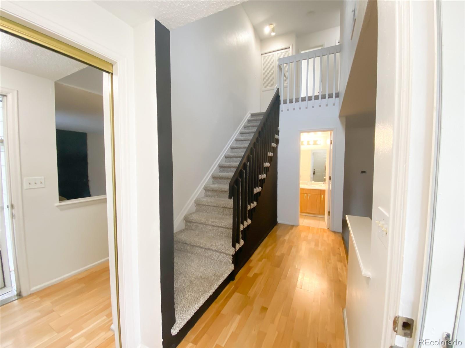 8423 Everett Way, Unit B Arvada, CO 80005 - Photo 3 of 27 a view of a hallway with wooden floor and staircase