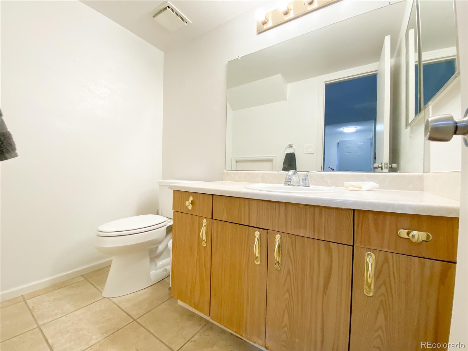 8423 Everett Way, Unit B Arvada, CO 80005 - Photo 5 of 27 a bathroom with a sink a toilet and mirror