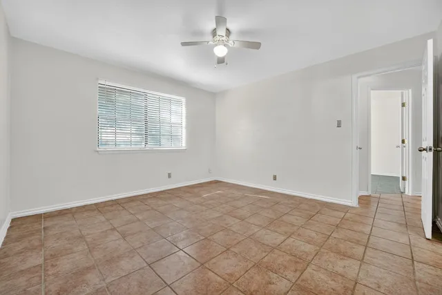 a view of an empty room with a ceiling fan and a window