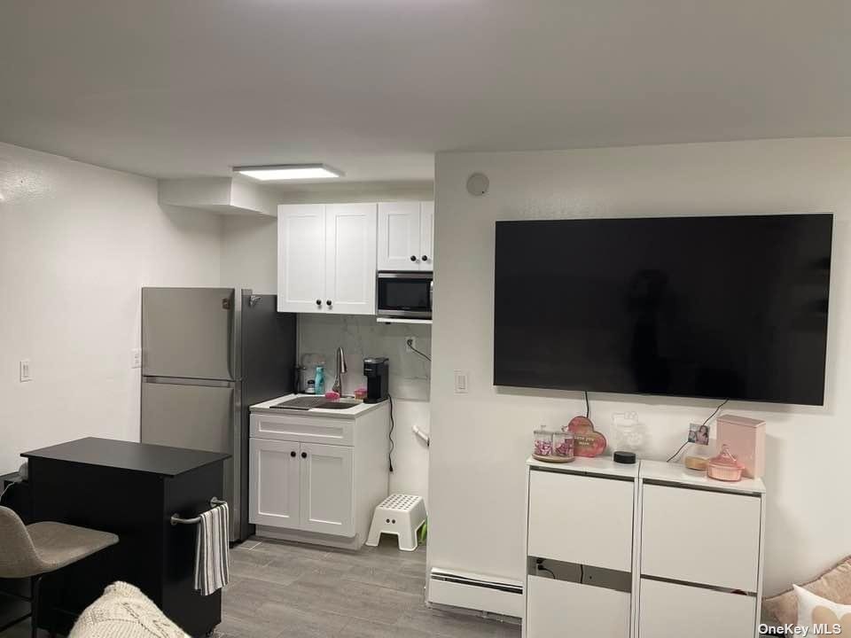 Undisclosed Address Queens, NY 11368 - Photo 8 of 9 a kitchen with stainless steel appliances kitchen island sink refrigerator and cabinets