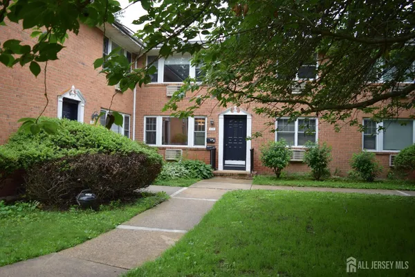 a front view of a house with a garden and yard