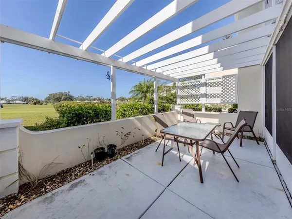 a view of a patio with table and chairs with wooden floor and fence