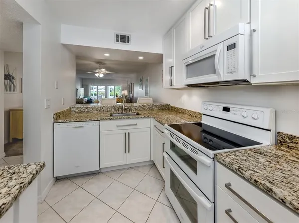 a kitchen with granite countertop cabinets stainless steel appliances and a counter space