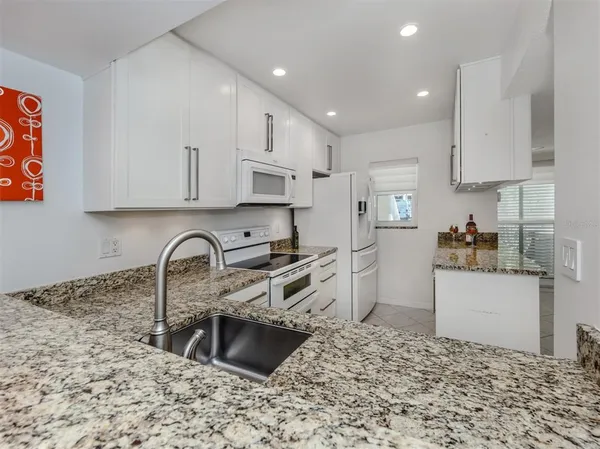 a kitchen with stainless steel appliances kitchen island granite countertop a sink stove and cabinets