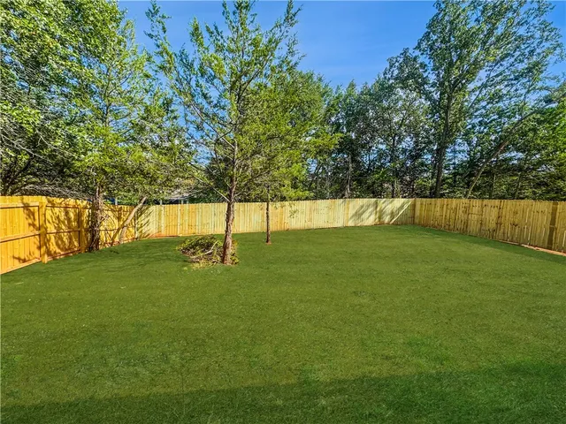 a view of yard with swimming pool and trees in the background