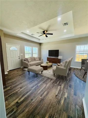 a living room with furniture and a wooden floor