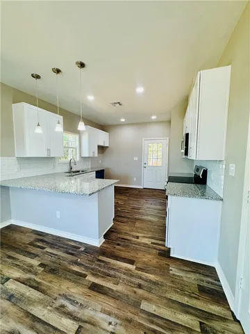 a large kitchen with kitchen island a sink stainless steel appliances and cabinets