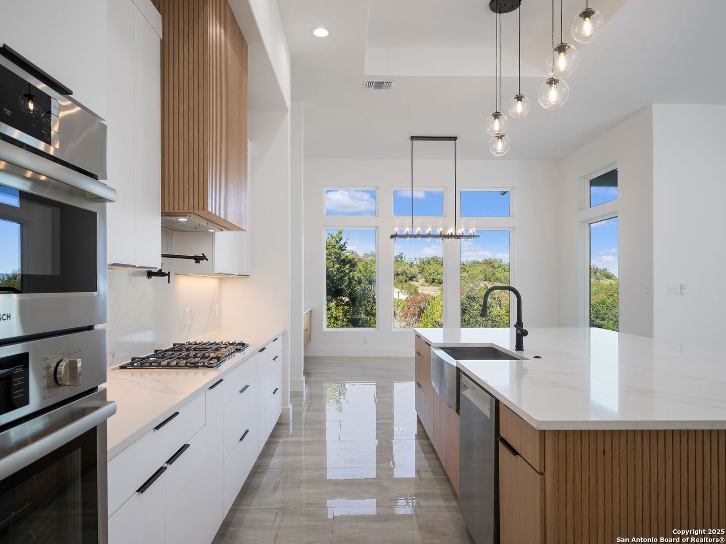 10907 Nina Ridge San Antonio, TX 78255 - Photo 11 of 54 a kitchen with a sink stove and wooden cabinets