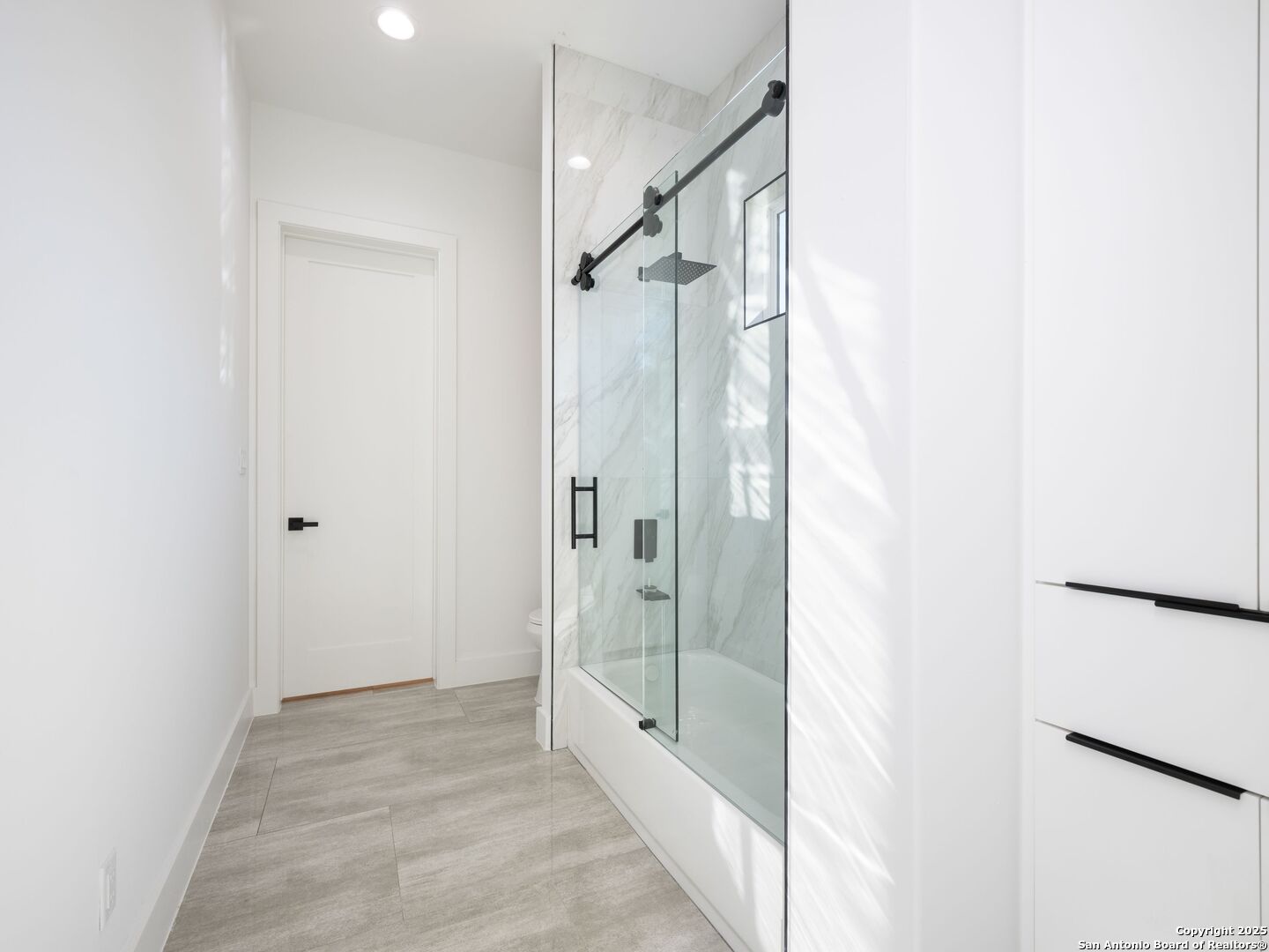 10907 Nina Ridge San Antonio, TX 78255 - Photo 34 of 54 a bathroom with a glass shower door