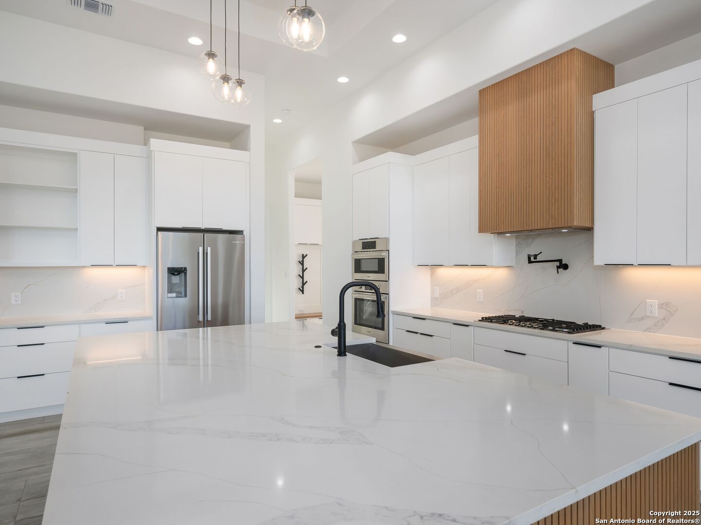 10907 Nina Ridge San Antonio, TX 78255 - Photo 8 of 54 a kitchen with granite countertop a stove a sink and a refrigerator