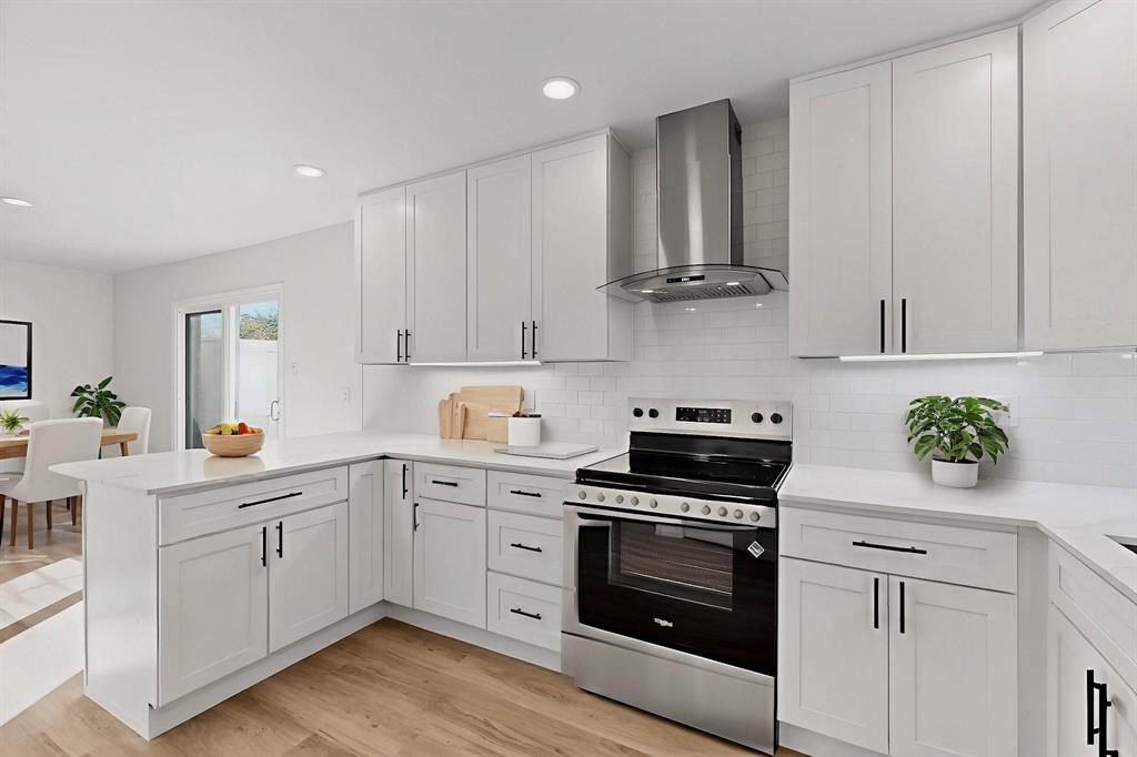 a kitchen with cabinets stainless steel appliances and wooden floor