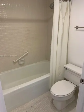 a white toilet sitting next to a bath tub