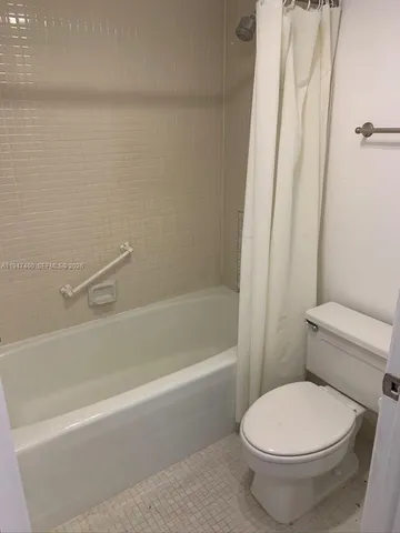 a white toilet sitting next to a bath tub