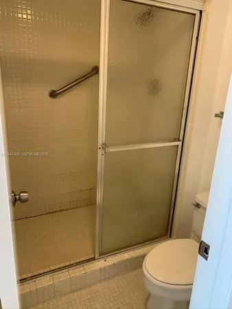 a white toilet sitting next to a shower