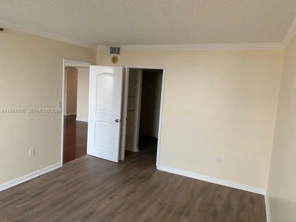 an empty room with wooden floor and closet
