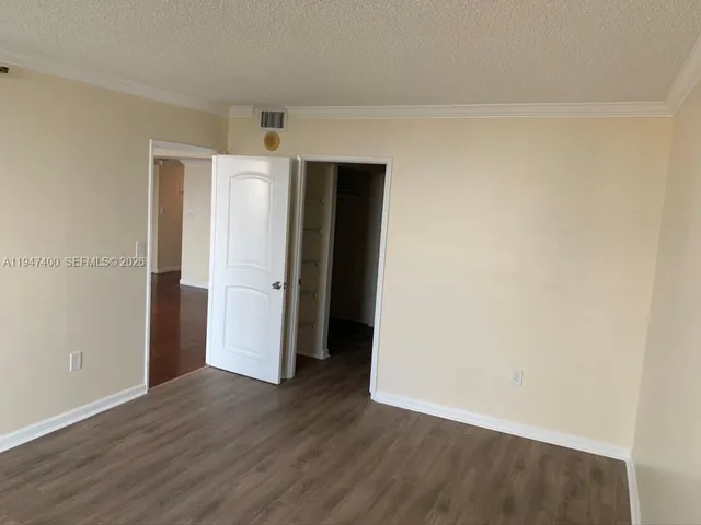 an empty room with wooden floor and closet