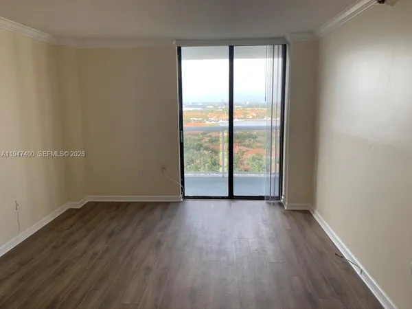 an empty room with wooden floor and sliding door